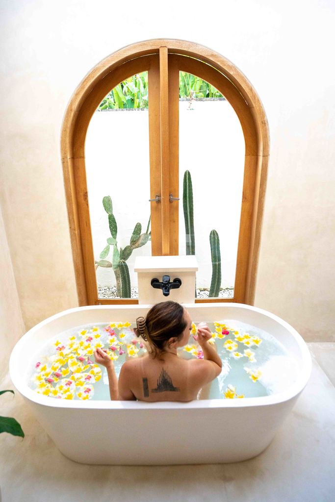 Woman taking a floral bath in a villa in Bali